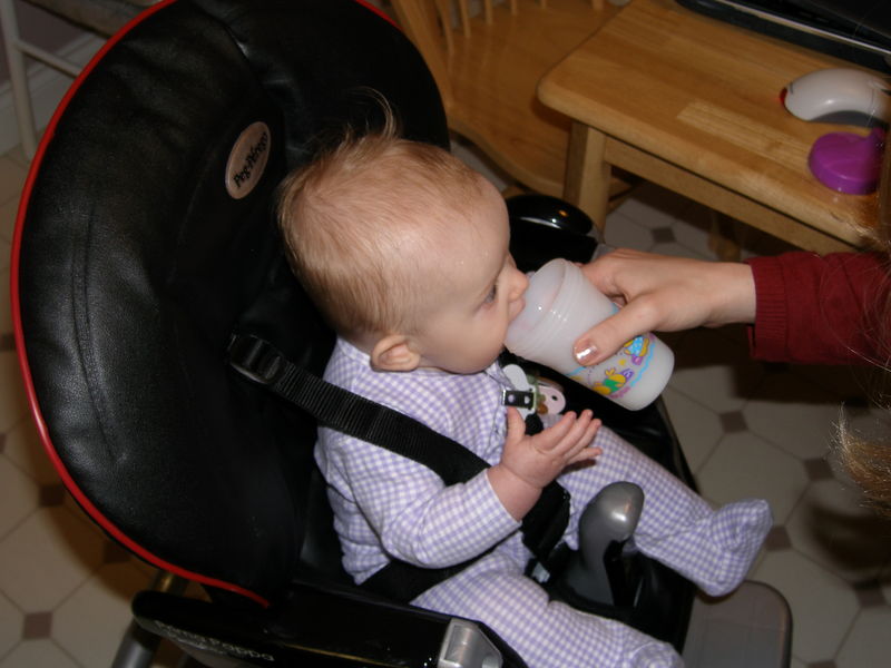 Drinking out of the cup with a little help from Mommy
