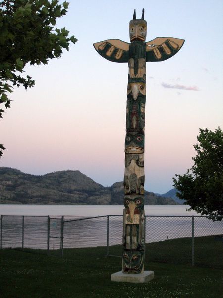 A totem pole in Peachland at sunset
