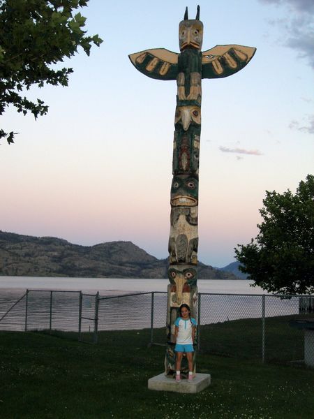 Kaija with a totem poll in Peachland at sunset
