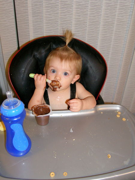 Feeding herself, with a spoon
