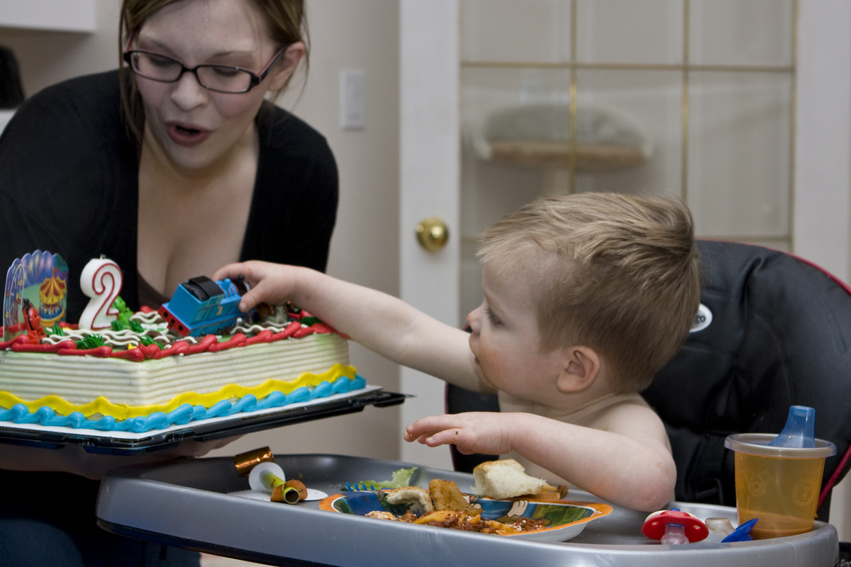 Heather blows out the candle as James reaches for the cake; disaster avoided
