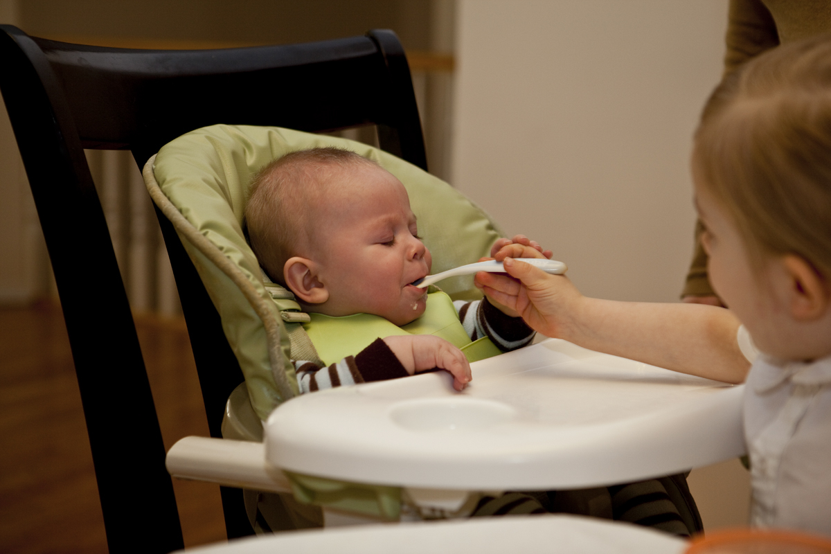 Thomas's very first bite of solid food ever, delivered by his big sister Maddi
